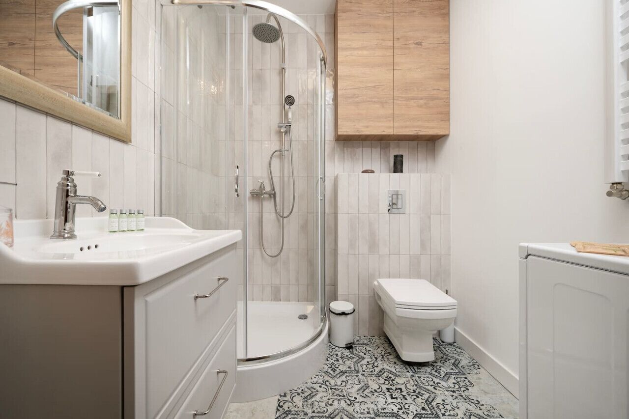 A modern bathroom with a shower, toilet, and vanity.