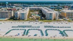 A resort with multiple high-rise buildings, a central pool area, and a beach with umbrellas. - Closest 2 Bedroom to Beach Spectacular Gulf, Pier, & 🐬 View at A403 Waterscape (Fort Walton Beach)
