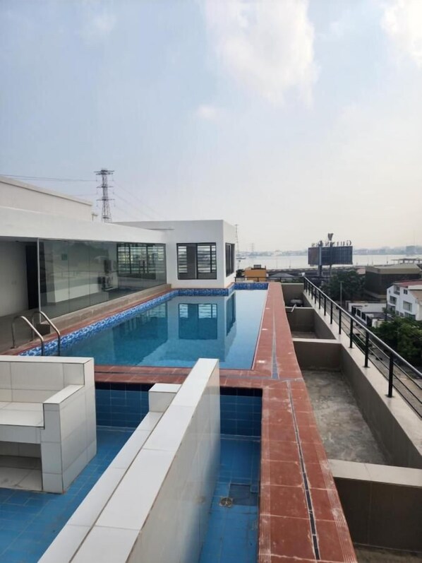 A rooftop swimming pool with a clear view of the city skyline. - Wonder Court 2 Hotel and Apartment (Lekki)