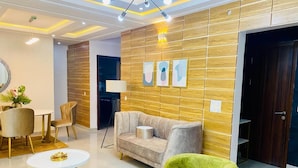 A modern living room with a sofa, green armchair, and a round coffee table.