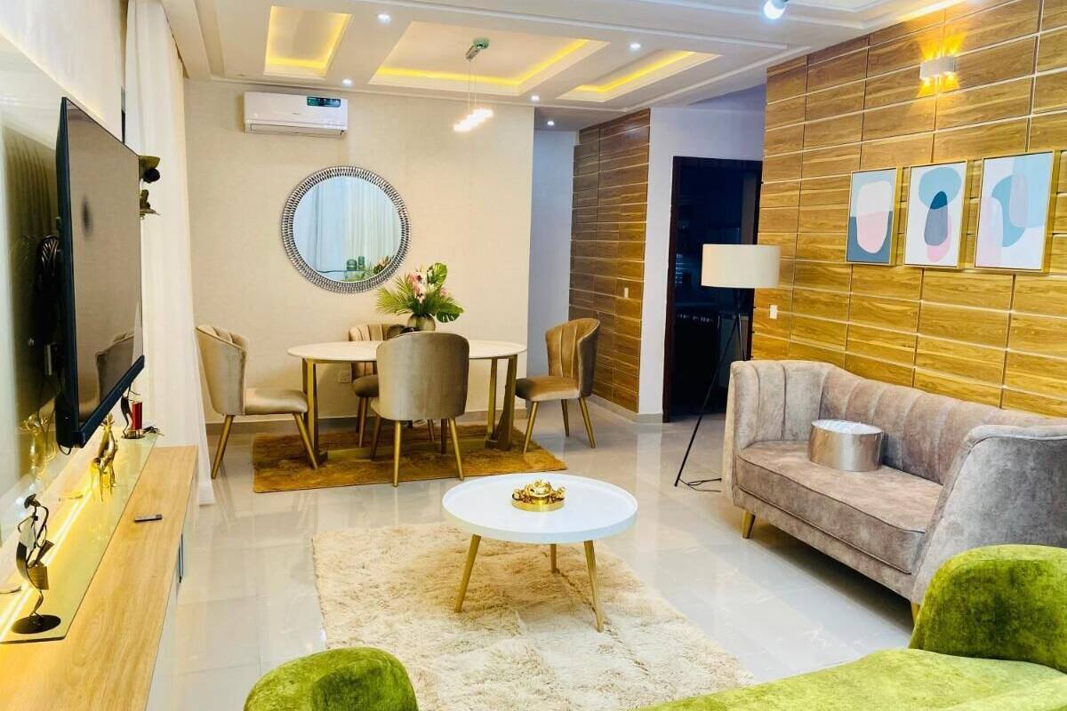 A modern living room with a round dining table, a sofa, and a TV.