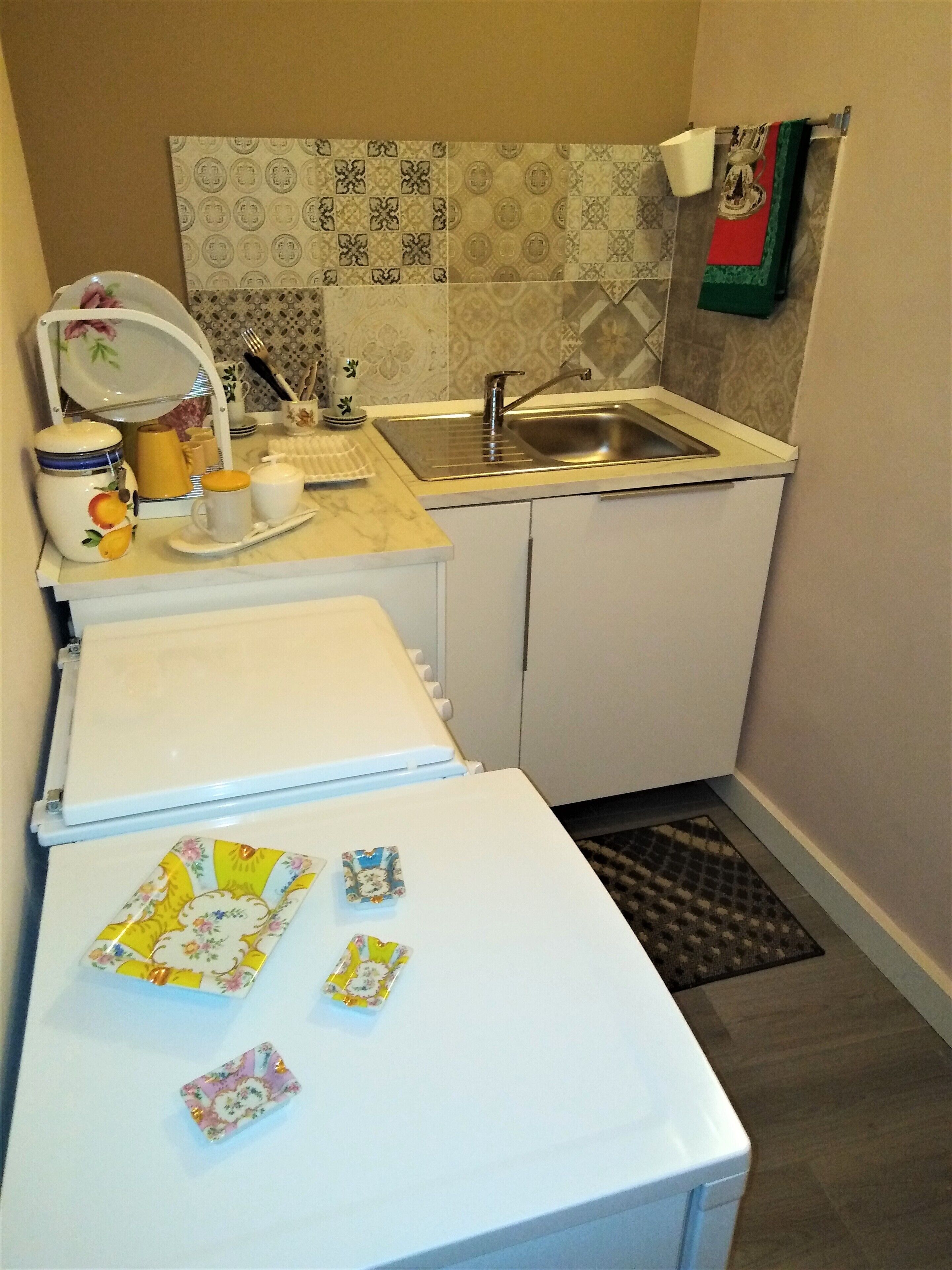 A compact kitchen with a sink, a refrigerator, and a microwave.