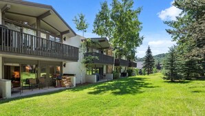 A modern residential building with a spacious outdoor area, including a patio and a well-maintained lawn. - Lichenhearth 08 (Snowmass Village)