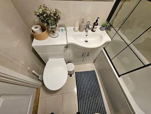 A bathroom with a toilet, sink, and shower area. - Islington Flat close to King’s Cross (Greater London)