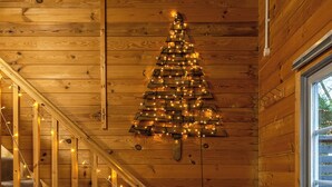 A wooden staircase with string lights, a wooden ceiling, and a window. - Walliswood Lodge - Rural Retreat - Newly converted, Wood Burner, Air Con, wi-fi (Dorking)