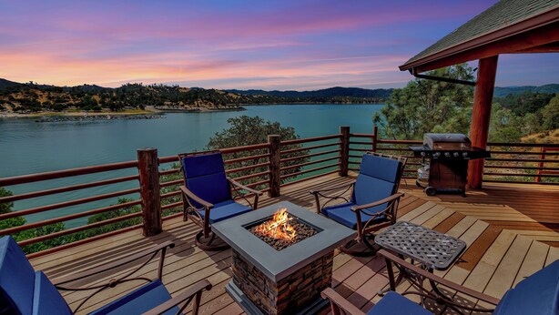 Una terrazza con un focolare, posti a sedere all'aperto e un barbecue.