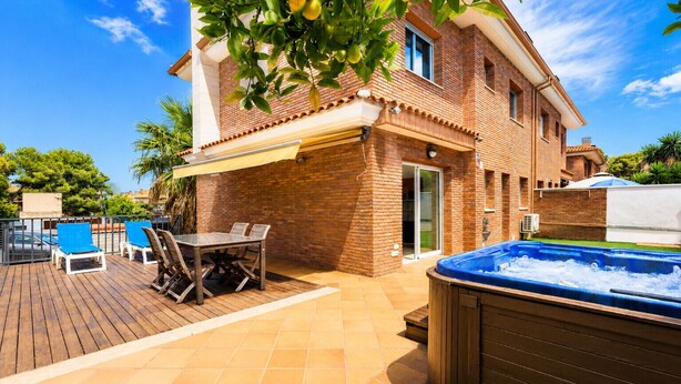 Una casa con patio, jacuzzi y piscina.