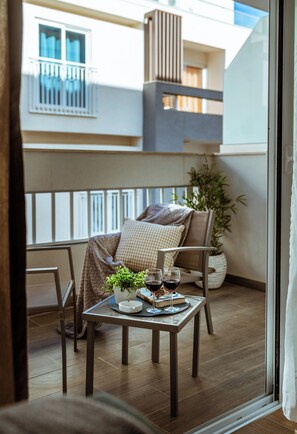 Enjoy a romantic dinner for two on this balcony with a view, complete with a table setting and a potted plant.