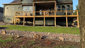A two-story house with a covered deck and a stone facade. - Beautiful New 4-bedroom home on Granada Golf Course in Hot Springs Village. (Hot Springs Village)
