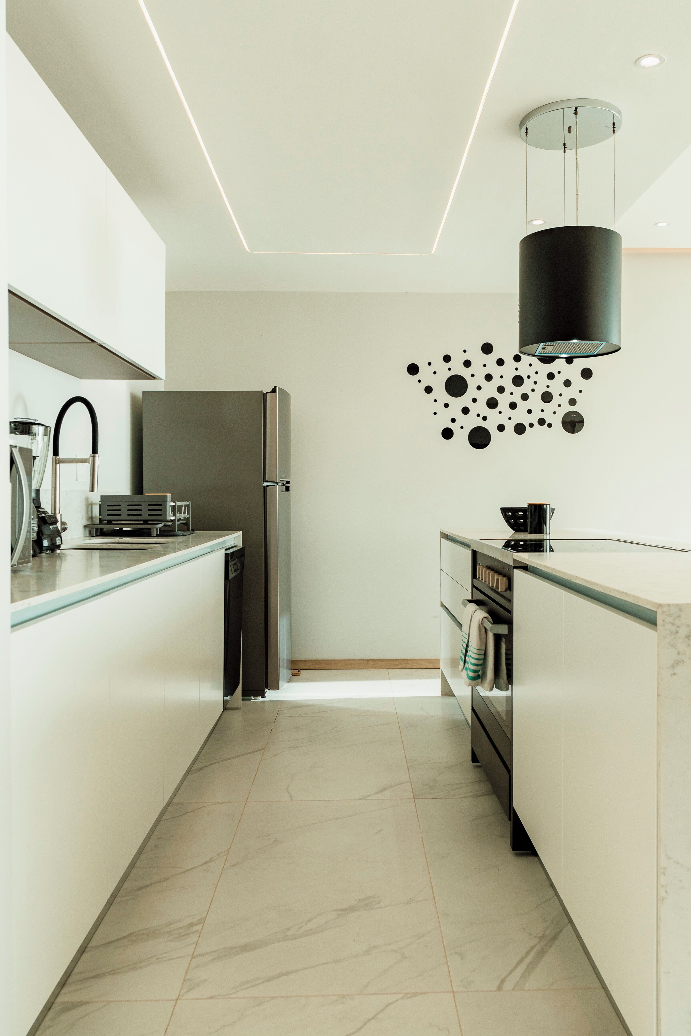 A modern kitchen with a central island, stainless steel appliances, and a decorative wall art piece.