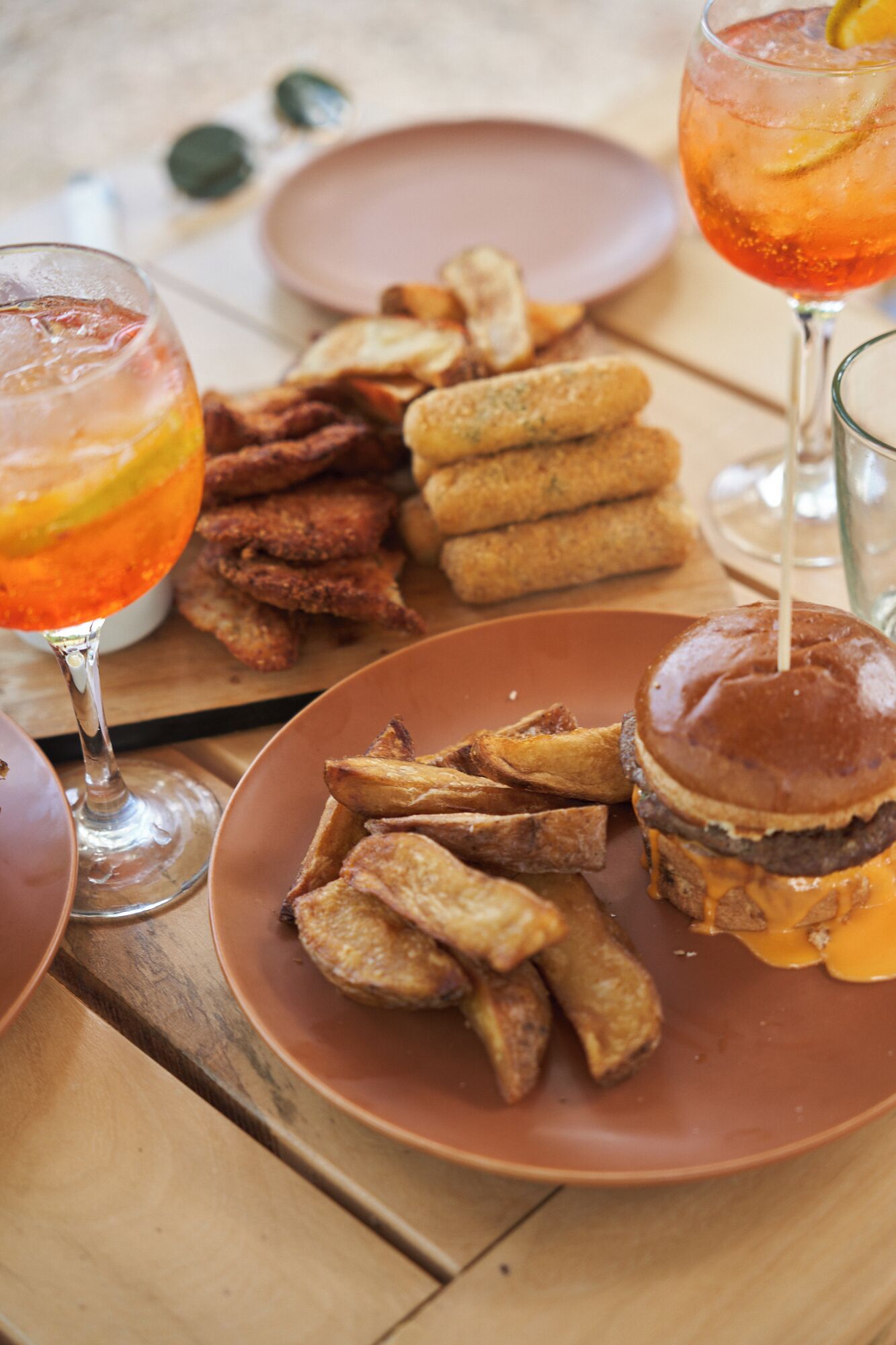 A table with food items including a burger, fries, and a drink.