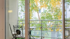 A room with a sliding glass door leading to a balcony with artificial grass and metal chairs. - Le Spacieux de Dizier - Proche place des Vosges (Nancy)