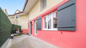A narrow alleyway with a building painted in red and grey, featuring a door and windows with shutters. - Batié - Appt 4 personnes à Mulhouse (Mulhouse)
