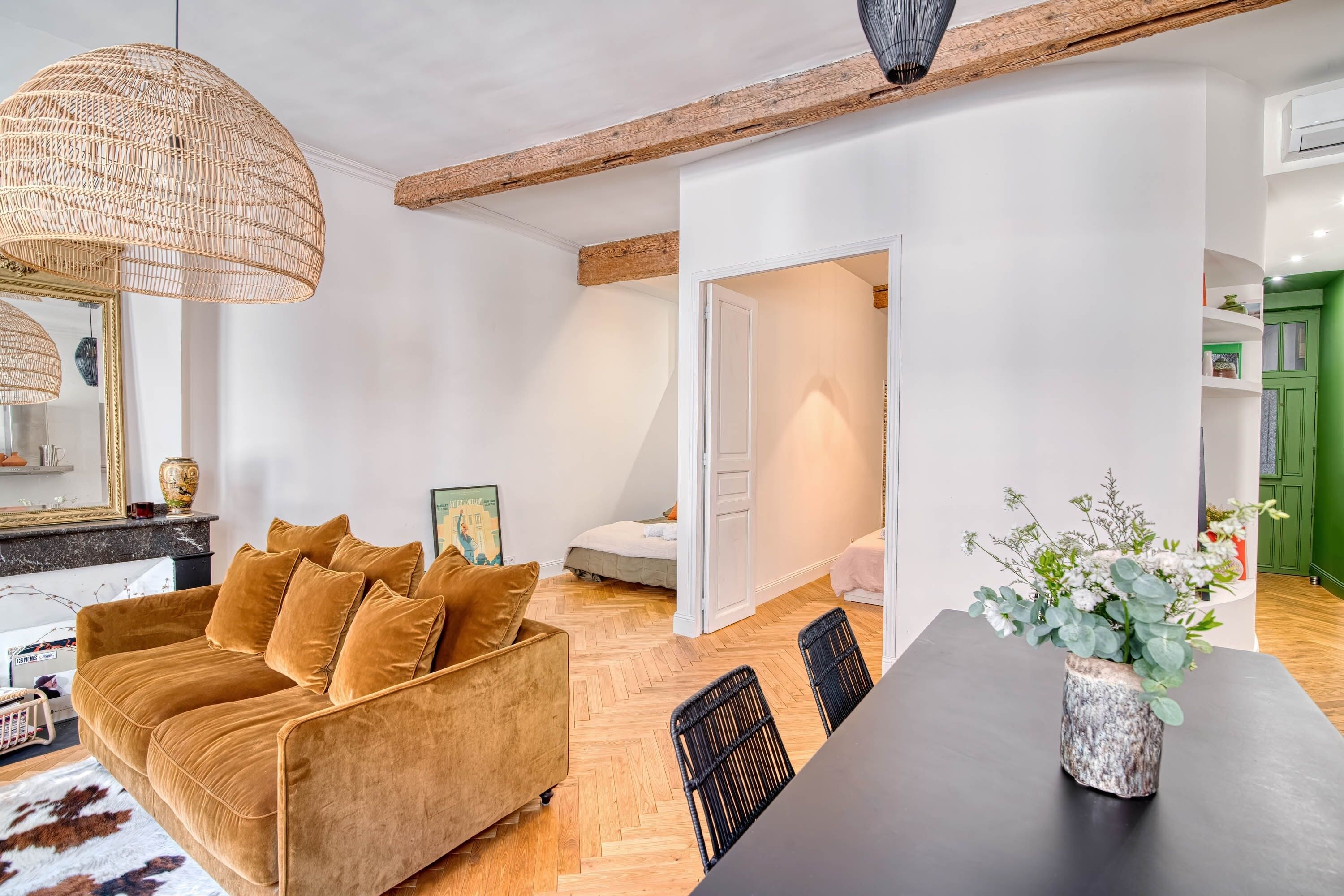 Ein modernes Wohnzimmer mit einer Couch, einem Esstisch und einer Pendelleuchte.