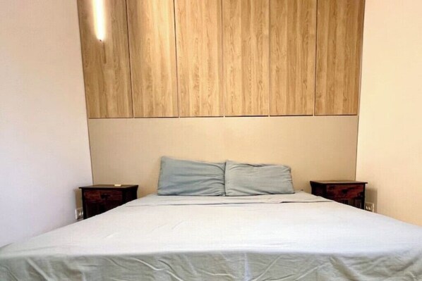A bedroom with a bed, two nightstands, and a wooden headboard. - NIce Flat in Villa Near Old Town
(București)