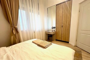 A bedroom with a bed, a desk, and a mirror. - NIce Flat in Villa Near Old Town
(București)