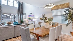 Un salon moderne comprenant un canapé, une table à manger, des chaises et un vase décoratif.