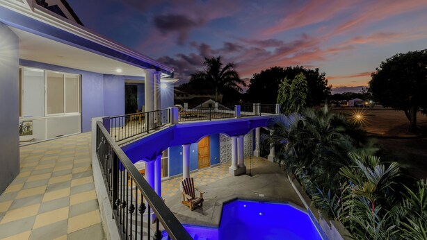 Un edificio de dos pisos con un balcón que da a una piscina.