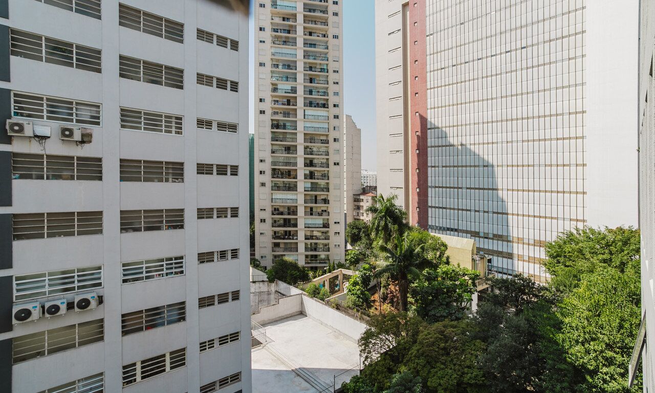 A high-rise building with multiple floors, large windows, and air conditioning units.