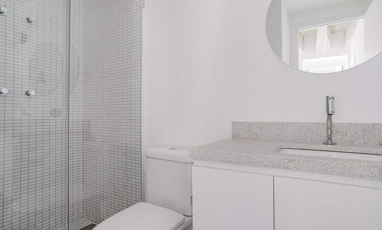 Un bagno con doccia, servizi igienici e lavandino.
