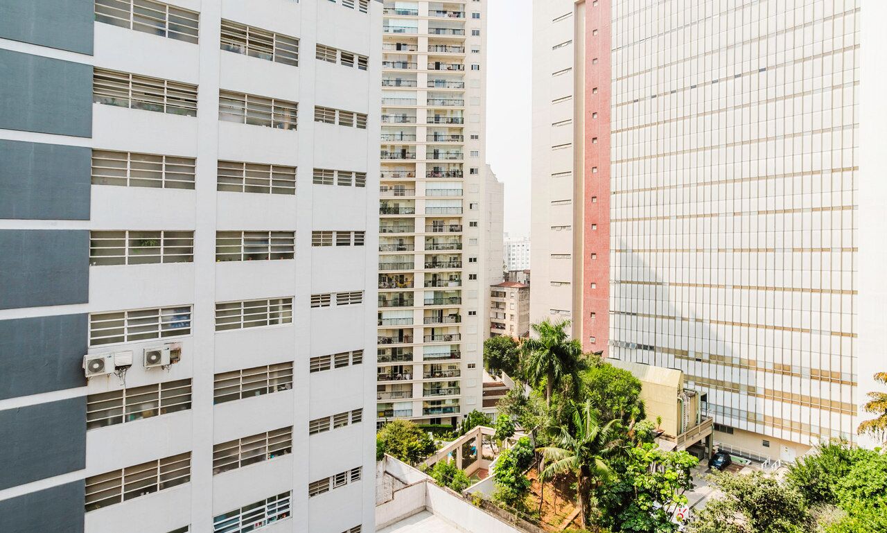Un immeuble de grande hauteur, doté de nombreux étages, de grandes fenêtres et de climatiseurs.