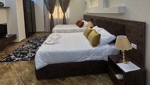 A modern hotel room with two beds, a TV, a desk, and a lamp. - Pharaonic Pyramids Hotel  (Giza)