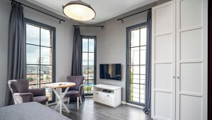 Una habitación de hotel moderna con un ventanal grande, televisión de pantalla plana, escritorio y cama.