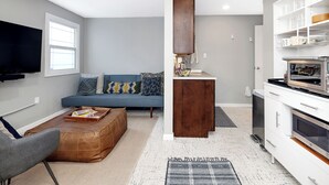 Un salon moderne avec un canapé, une table basse et un téléviseur.