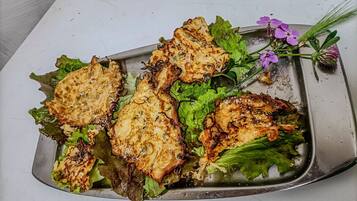 A tray with grilled chicken and greens on a white surface.
