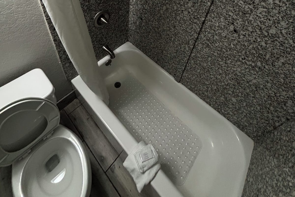 A bathroom with a bathtub, toilet, and shower.