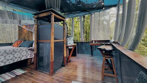 A room with a bed, a small table, a chair, and a wooden structure. - Morpho - adventurous Treehouse with amazing 360 view with pool and wifi access (Limón)