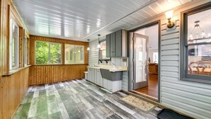 A spacious kitchen with wooden floors, a large window, and a view of the outdoors. - Mountain View 4BR Home with Fireplace & Ping Pong (Franklin)