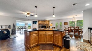A spacious kitchen with wooden cabinets, a central island, and pendant lighting. - Mountain View 4BR Home with Fireplace & Ping Pong (Franklin)