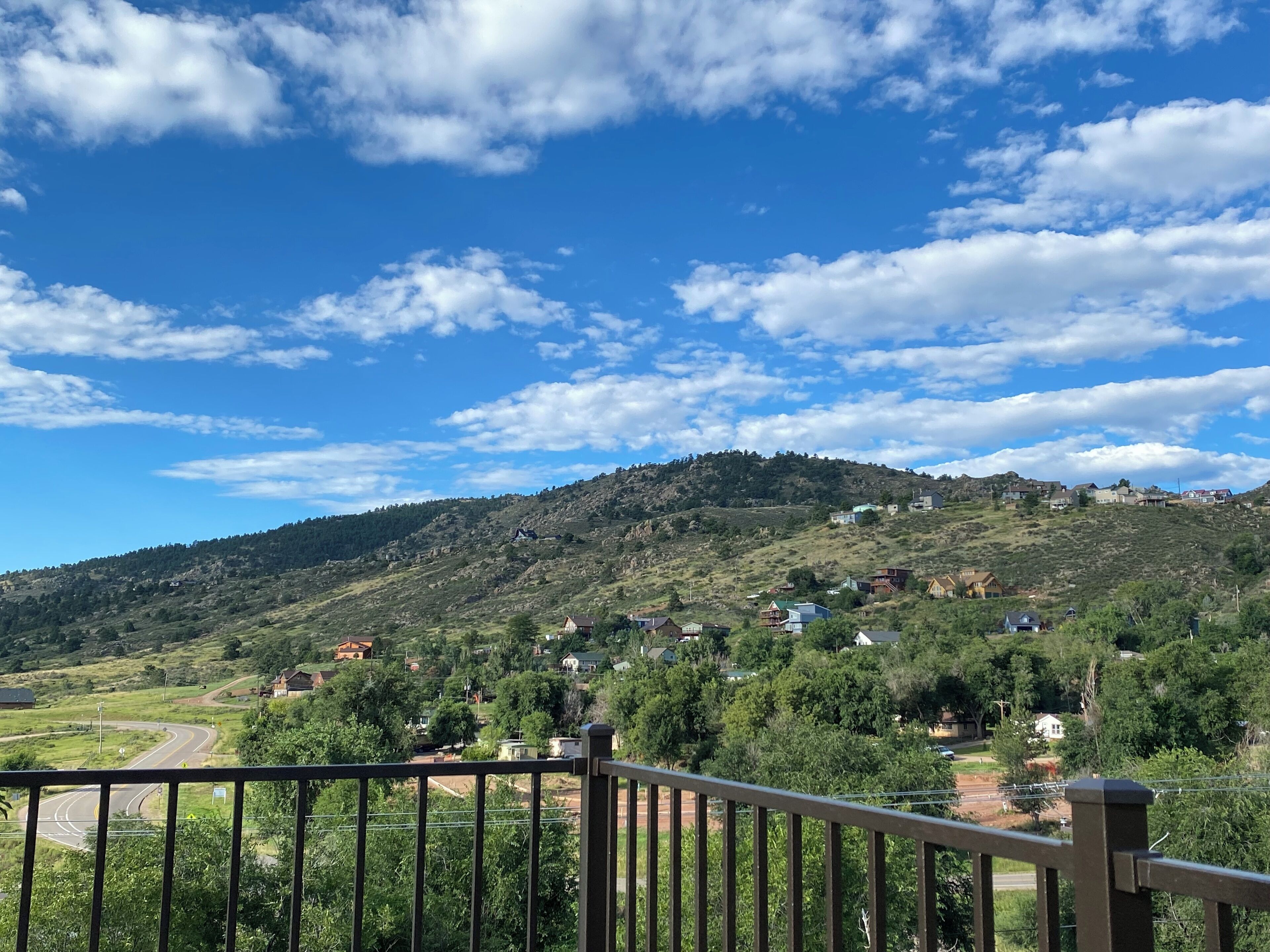 Vista panorámica de una colina con casas y un camino sinuoso.