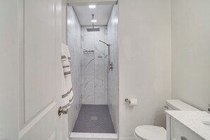A narrow bathroom with a shower, toilet, and sink. - 1 Mi to Gallatin Square! Family-Friendly Home (Gallatin)