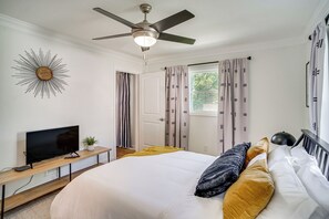 A bedroom with a bed, a ceiling fan, a TV on a wooden console, and a window with curtains. - 1 Mi to Gallatin Square! Family-Friendly Home (Gallatin)
