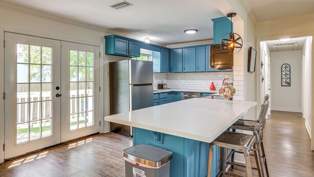 A kitchen with teal cabinets, a large island, and a stainless steel refrigerator. - 1 Mi to Moody Gardens & Beaches: Galveston Home (Galveston)