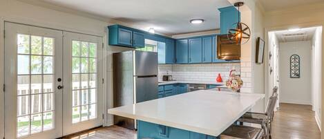Enjoy cooking in this well-equipped kitchen with a central island, oven, and stainless steel refrigerator.