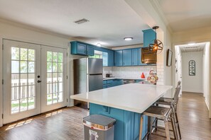 A kitchen with teal cabinets, a large island, and a stainless steel refrigerator. - 1 Mi to Moody Gardens & Beaches: Galveston Home (Galveston)