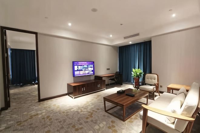Una sala de estar moderna con una televisión de pantalla plana, un sofá, una mesa de centro y un escritorio.