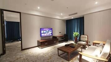 Una sala de estar moderna con una televisión de pantalla plana, un sofá, una mesa de centro y un escritorio.