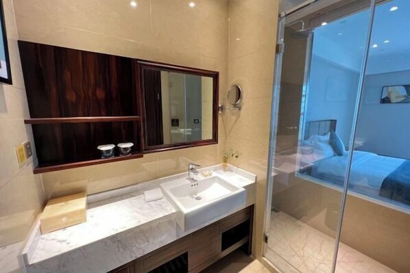 Un baño moderno con un espejo grande, lavamanos doble y cabina de ducha de vidrio.