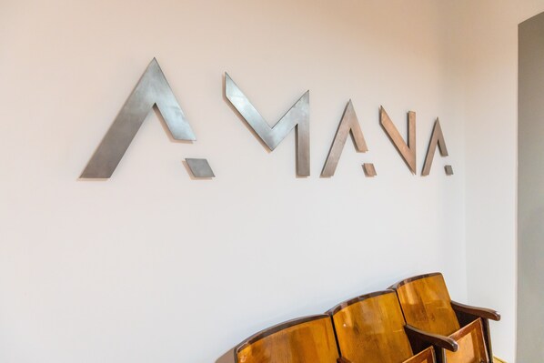 En vägg med bokstäverna ”AMANA” i metall.