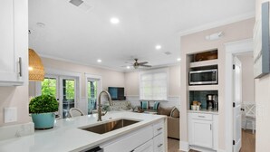 Una cocina moderna con armarios blancos, un lavamanos doble y un lavavajillas integrado.