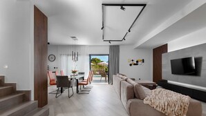 Ein modernes Wohnzimmer mit einer Couch, einem Fernseher und einer Treppe.