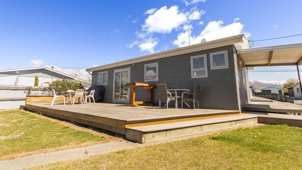 A single-story house with a patio area featuring outdoor furniture and a barbecue grill. - Aoraki Oasisl, FREE WIFI & SKY TV (Twizel)