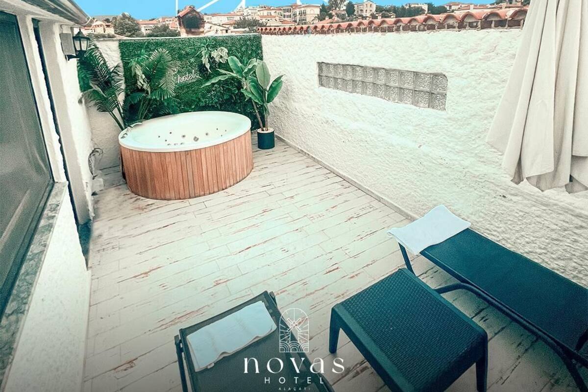A rooftop terrace with a hot tub, lounge chairs, and a view of the city.