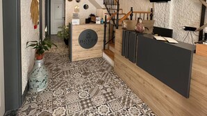 A hotel reception area with a modern design, a staircase, and a patterned floor. - Novas Hotel Alaçatı (Cesme)
