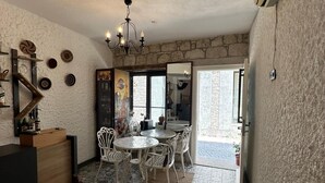 A dining area with a patterned tile floor, a chandelier, and a view of the outside. - Novas Hotel Alaçatı (Cesme)