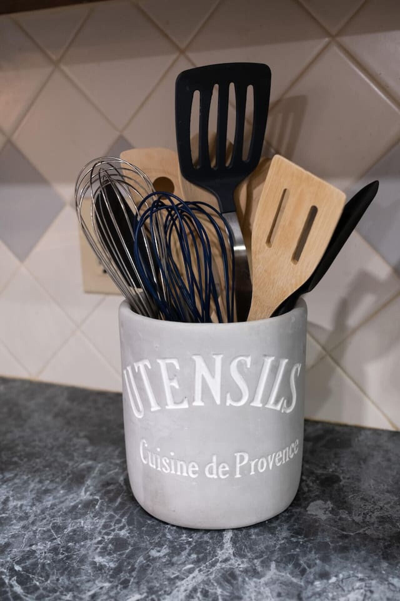 A kitchen utensil holder with a label reading "UTENSILS Cuisine de Provence" on a countertop.